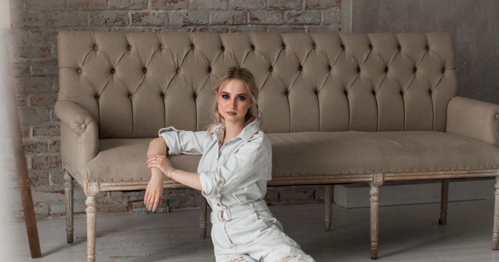 A lady with her hand on a leather sofa